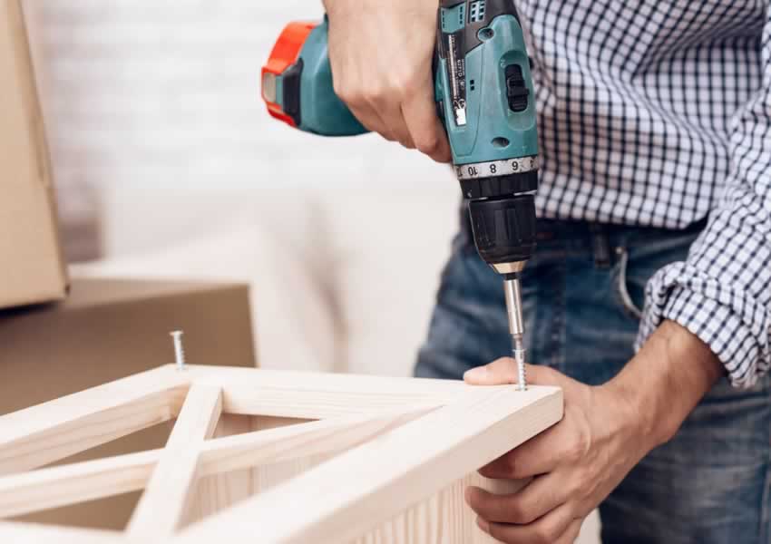 handyman assembles flat pack furniture