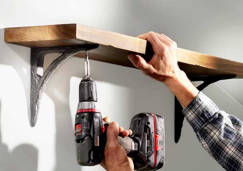handyman puts up shelf