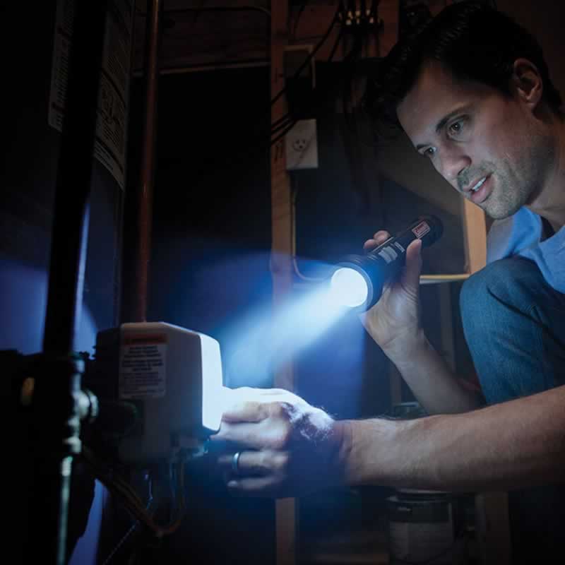 electrician checking out a consumer unit in a power cut / elecrical emergency situation by torchlight