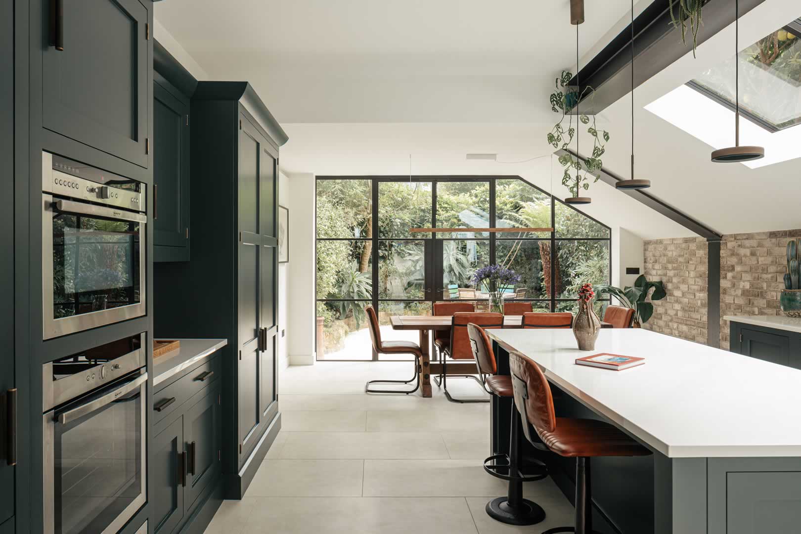 parsons green house new kitchen in extension showing kitchen units, new flooring and new fully-glazed patio doors leading to garden